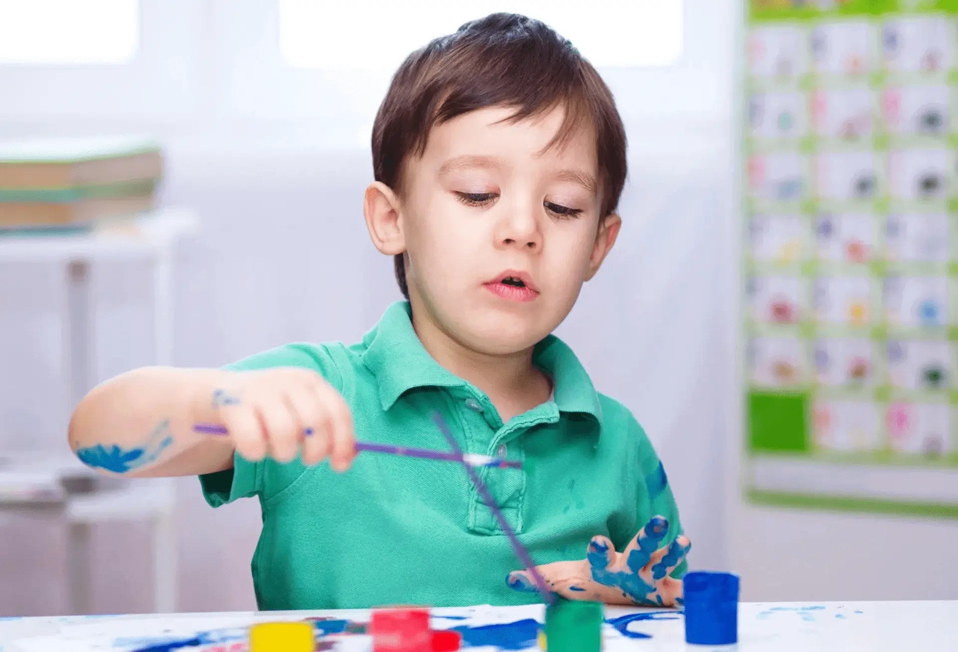 Boy concentrating while building with colorful toy blocks